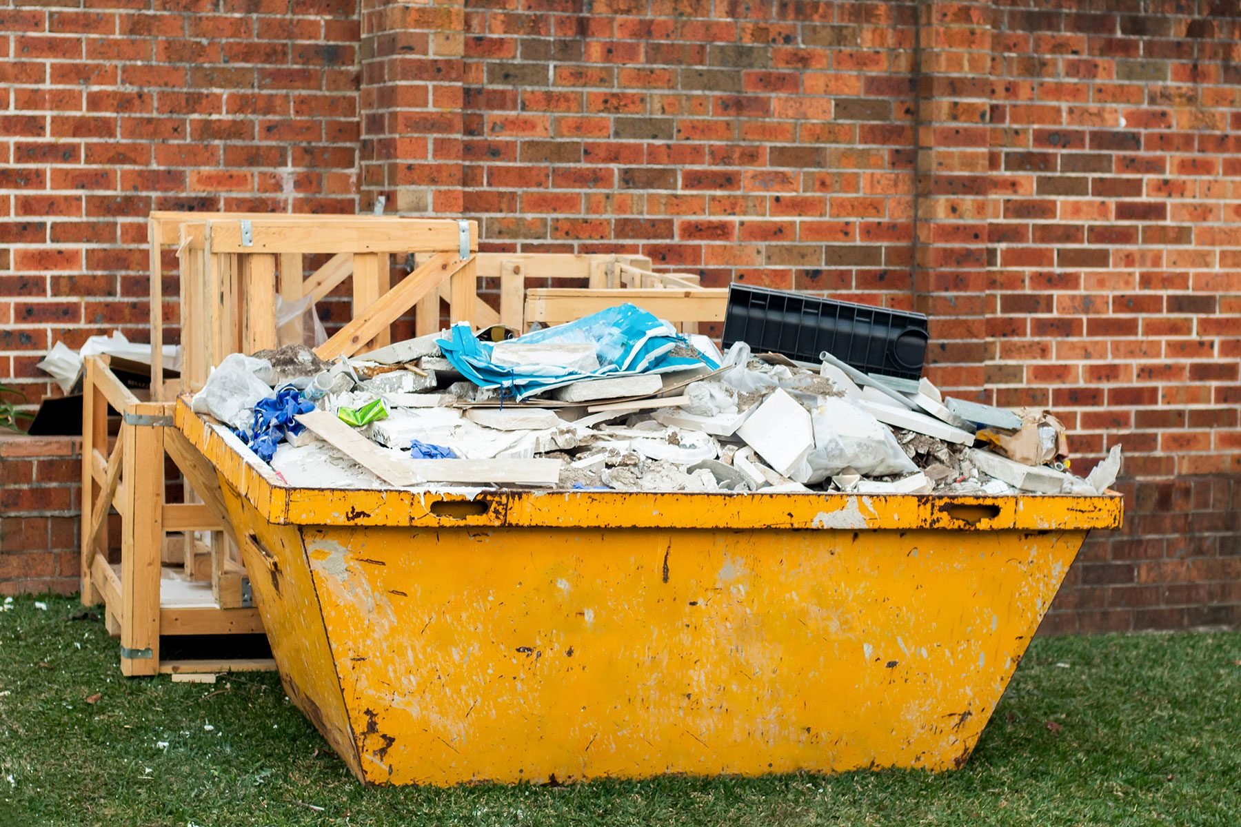 Dumpster with construction rubble in a backyard