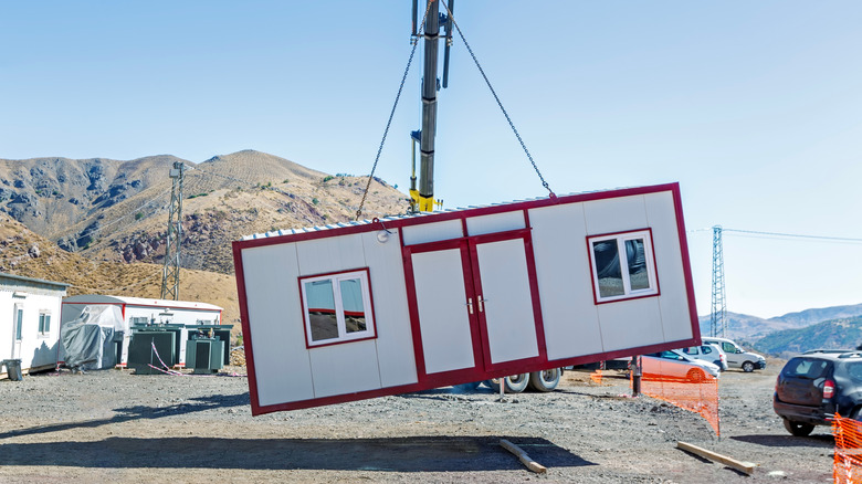 Une maison préfabriale soulevée avec une grue