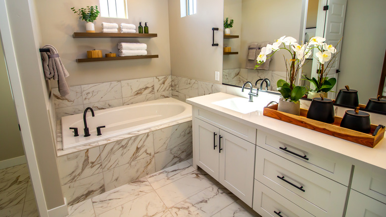 Une salle de bains en bourse en marbre avec une petite baignoire et un lavabo.