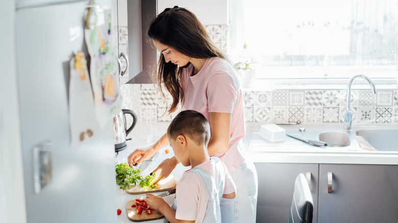 Maman enseignant à l'enfant pour tout-petit à cuisiner.