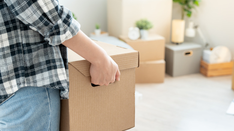 Personne tenant une boîte se préparant à se déplacer