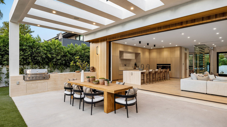 Cuisine extérieure avec une grille et comptoir intégrées contre une maison moderne.