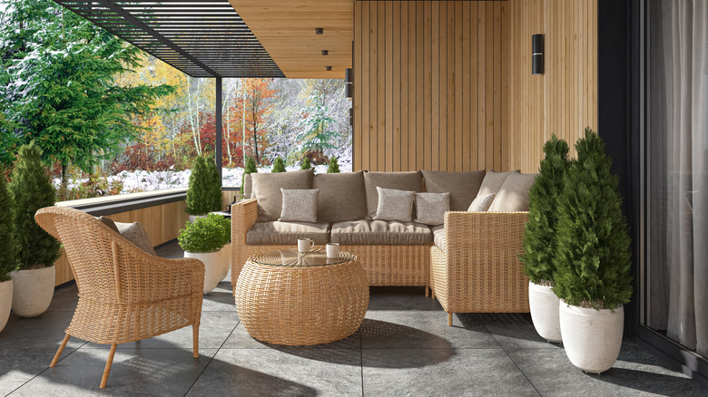 Un patio avec des meubles en osier et des murs en bois.