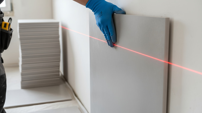 Ouvrier du bâtiment s'assurant qu'un mur est carré