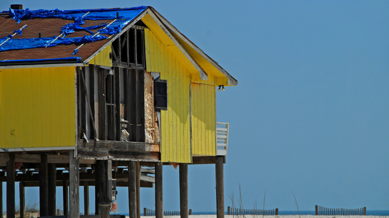 Une maison sur pilotis endommagée par le vent près de l'océan