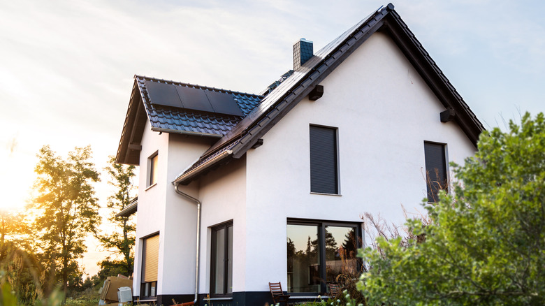 Une maison blanche avec des bordures noires par une journée ensoleillée
