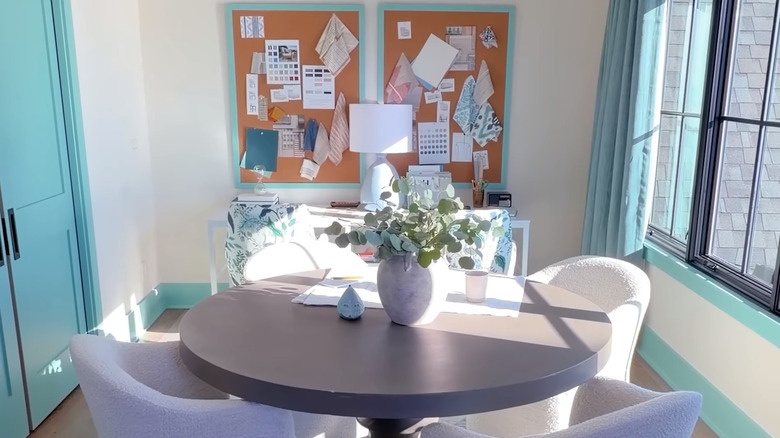 La buanderie de la maison de rêve 2026 de HGTV avec des garnitures et des détails bleu vif, des murs blancs et une table confortable et fonctionnelle au centre