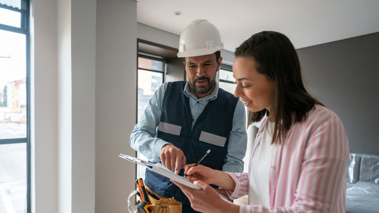 Un propriétaire parle à un entrepreneur de la paperasse