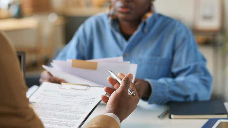 Deux personnes assises l'une en face de l'autre et examinant des documents juridiques