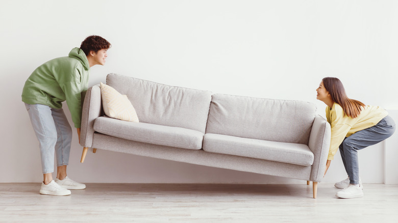 Couple déplaçant un canapé