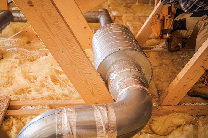 Installation de conduits dans un grenier résidentiel pendant le processus de rénovation domiciliaire