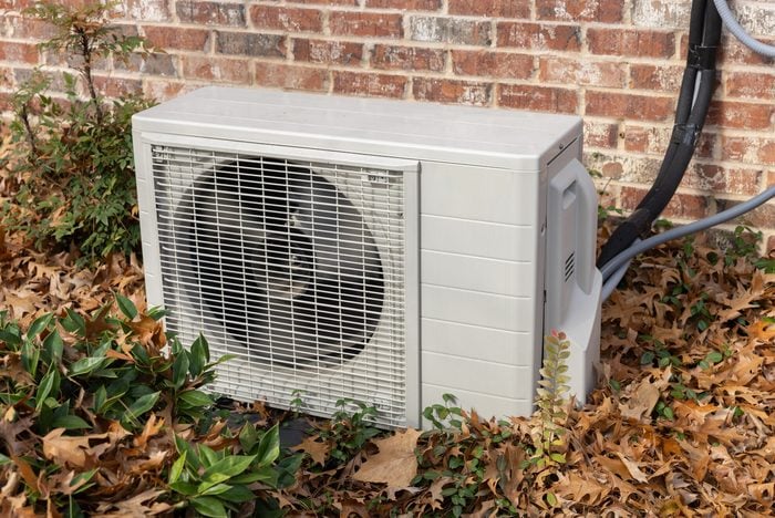 Unité de climatisation entourée de feuilles d'automne
