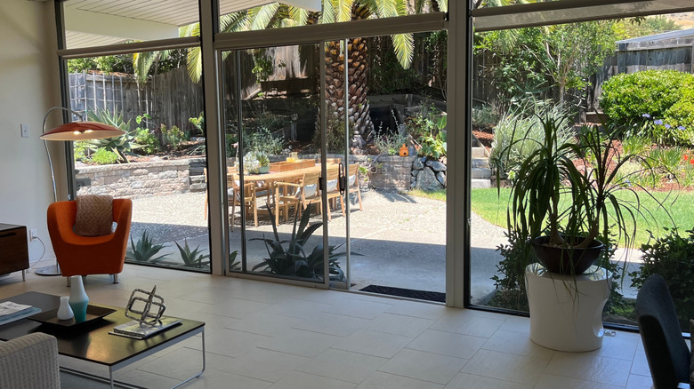 Intérieur de la maison Eichler, donnant depuis le salon sur le patio à travers des baies vitrées