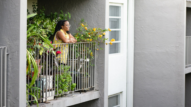 Personne bénéficiant d'un balcon avec des plantes dans un immeuble