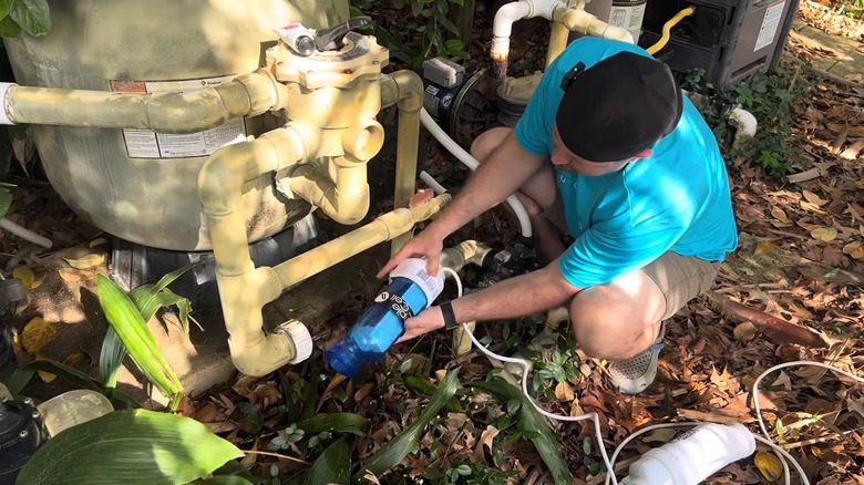 Un homme changeant la cellule de sel d'une piscine d'eau salée