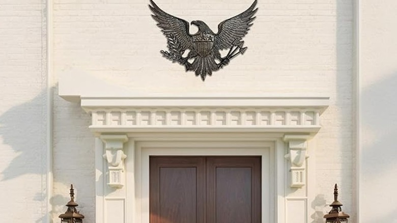 Une plaque d'aigle noir en haut d'une porte d'entrée en bois