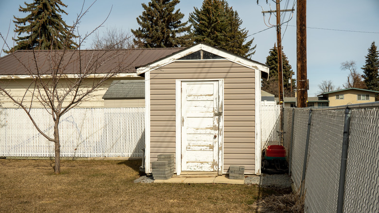 Un petit hangar portable dans le jardin d'une maison