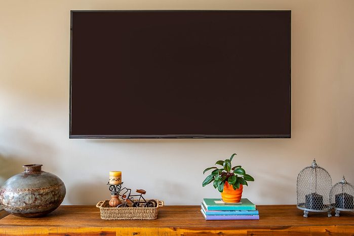Une télévision murale au dessus d'un buffet
