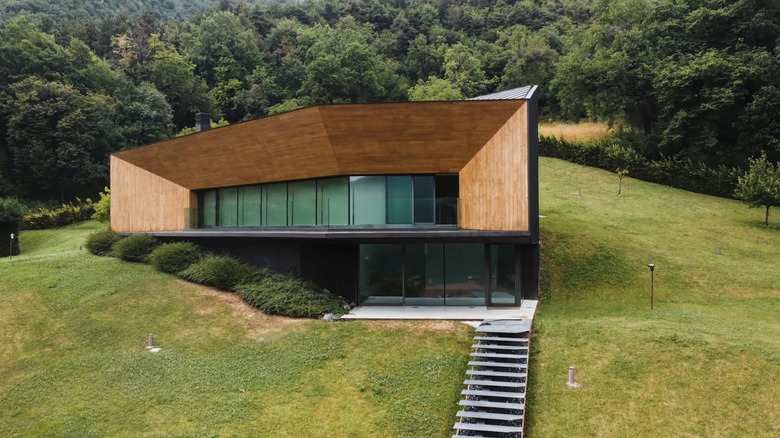 Maison à bermes moderne avec forêt en arrière-plan