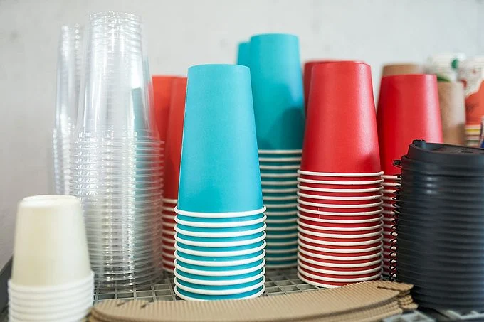 Tasses à café et couvercles colorés affichés sur une table dans un café