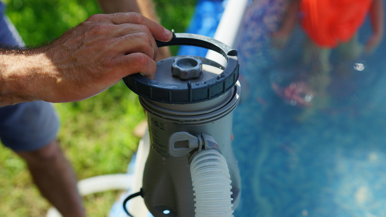 Une personne qui change un filtre de piscine